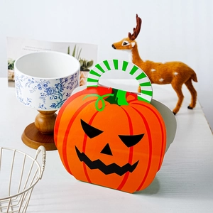 Detail view of pumpkin-shaped Halloween gift box with a green handle and Jack-o'-lantern face