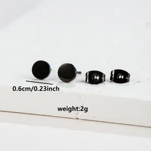 Macro view of 6mm black stainless steel stud earrings with butterfly backs on marble