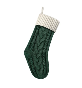 Dettaglio di una calza di Natale verde in maglia con bordo bianco e trama intrecciata