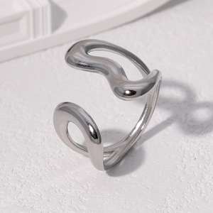Irregular silver geometric open ring in stainless steel on a textured stone background