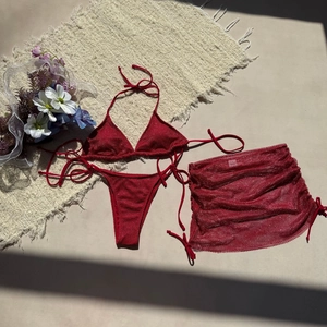 Vue à plat d'un bikini rouge 3 pièces en tissu pailleté avec paréo en maille assorti