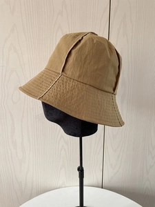 Detail view of khaki nylon bucket hat with reinforced stitching on the brim and side panel