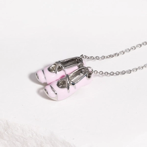 Detail view of dainty pink enamel ballet slippers pendant on a silver-tone chain