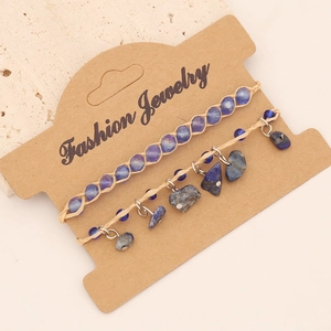 Detail of bohemian layered bracelets with blue beads and raw natural stone charms