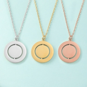 Detail of rotating double-layer geometric round pendants in gold, silver, and rose gold