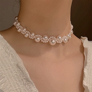 Close-up of elegant woven pearl choker necklace worn on model for a vintage look