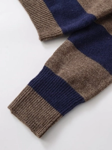 Detail of striped knit polo sleeve with coffee and navy bands and ribbed cuff texture