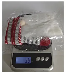 Detailed view of the 36g lightweight knitted Santa wine bottle cover on a digital scale