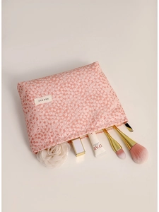Pink seersucker makeup bag with 3D texture and gold zipper for travel skincare storage