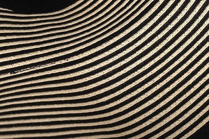 Detailed macro shot of French retro black and beige striped woven straw hat texture