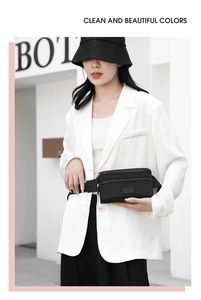 Detailed view of a black oxford fabric waist bag styled with a white blazer outfit