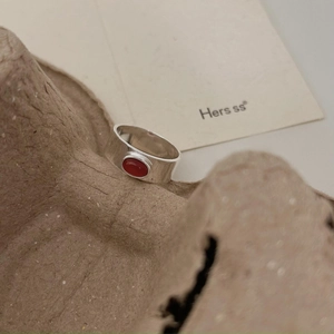 Detailed macro view of wide silver ring band featuring an oval red agate gemstone stone