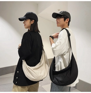 Modèles portant des sacs croissants en nylon beige et noir avec bandoulières réglables