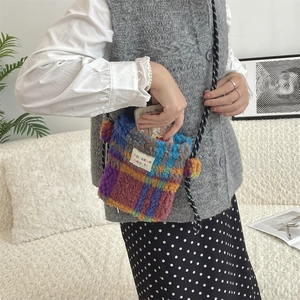 Macro view of plush checkered crossbody bag capacity showing a smartphone fit