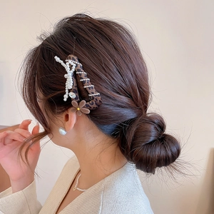 Nahaufnahme der Haarspange mit Leopardenmuster, Perlenkreuz und brauner Samtblüte