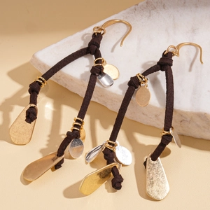 Detail of bohemian drop earrings with brown suede cords and hammered metal sequins