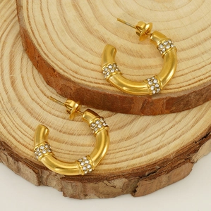 Détail des boucles d'oreilles en bambou doré 18 carats avec cristaux de zircone brillants