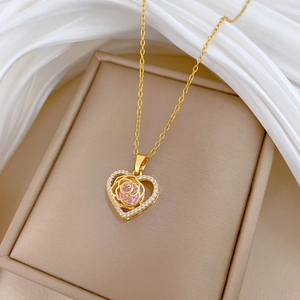 Macro shot of rose gold heart necklace with pink stone and small crystals in a gift box