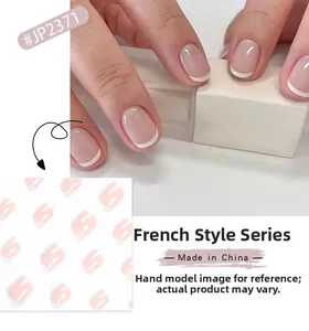Detailed view of short round French tip press-on nails in nude pink and classic white