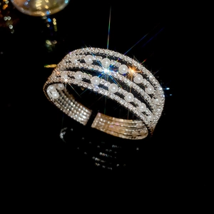 Macro view of multi-layer open cuff bracelet featuring crystals and white pearls