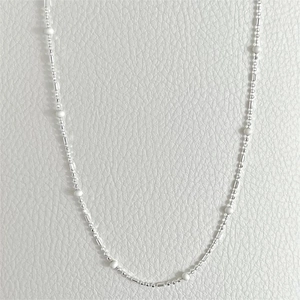 Detailed view of 925 silver necklace featuring delicate white round beads on a slim chain
