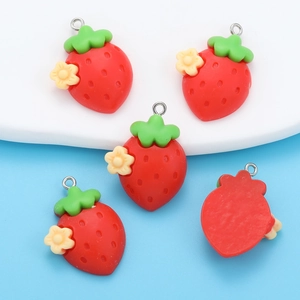 Detail view of 5 red resin strawberry pendants with green leaves and yellow flowers