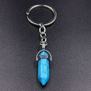 Detail of turquoise hexagonal pillar pendant with silver alloy ring on grey background