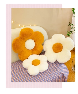 Detailed close-up of plush flower cushions in orange and white on a cozy sofa
