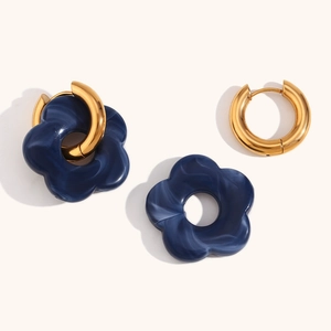 Detail showing the detachable gold hoops and dark blue marbled flower charms of the earring