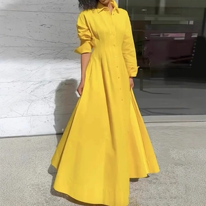 Detail of elegant yellow button-down shirt dress with pleated waist and long flowing hem