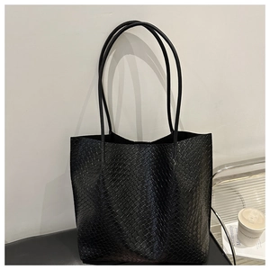 Detailed view of the black woven texture and dual straps on this large tote bag
