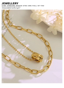 Macro detail of 18K gold-plated double-layer necklace with beaded and oval linked chains