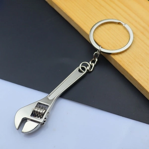 Macro shot of silver mini adjustable wrench keychain with rotating nut and metal chain