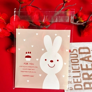 Detail of self-adhesive cookie bag with cute rabbit print and heart pattern on red background