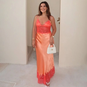 Détail d'une robe élégante en satin orange avec dentelle et décolleté plongeant en V