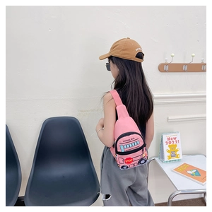 Pink school bus shaped kids chest bag shown on child's back in a minimalist setting