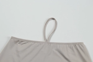 Macro detail of fine grey fabric stitching and sleek thin strap on women's slim outfit