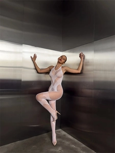 Detail van witte mesh bodysuit met opengewerkt patroon en blote rug op model