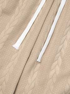 Macro shot of khaki cable knit fabric texture with white braided drawstring detail