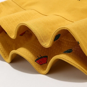 Detailed close-up of yellow sun hat featuring cute watermelon embroidery and neat stitching