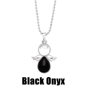 Macro detail of angel wing pendant featuring a black onyx gemstone on a ball chain