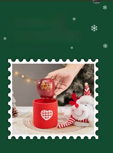 Detail of red knit Christmas gift basket with heart patch, plush elk, and apple ornament