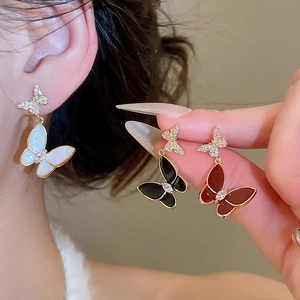 Detailed macro view of enamel butterfly stud earrings with sparkling zircon crystals