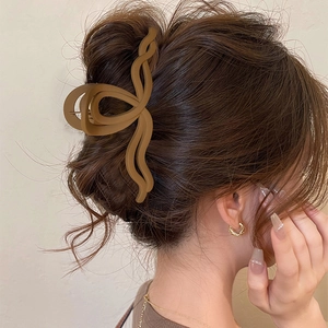 Primo piano di un mollettone per capelli marrone opaco su uno chignon elegante