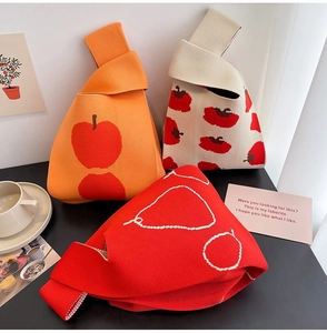Three knitted tote bags featuring red apple and pear patterns in a lifestyle setting