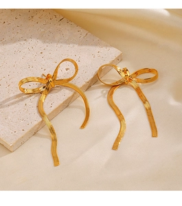 Détail de boucles d'oreilles nœud plaqué or 18K avec pampilles sur pierre beige
