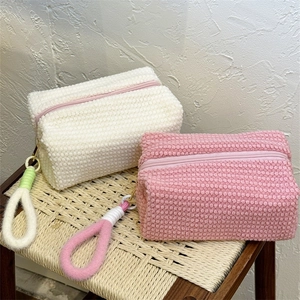 Detail view of pink and white plush travel makeup bags with soft textured fleece fabric