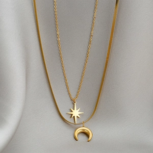 Double-layered gold necklace with octagonal star and crescent moon pendants on satin