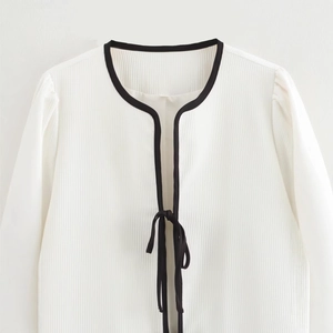Women's casual white pleated cardigan with black contrast trim and front tie closure