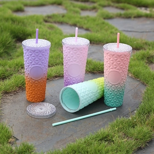 Detail of gradient plastic tumblers with diamond texture and matching straws outdoors